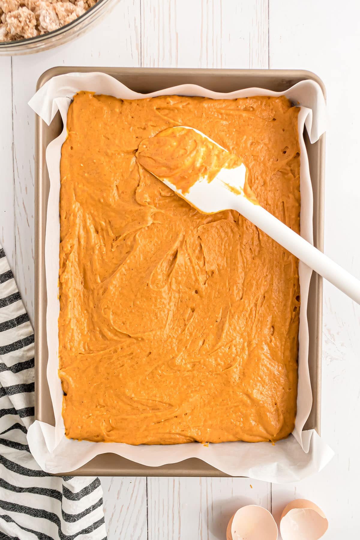 pumpkin cake batter spread out in a cake pan