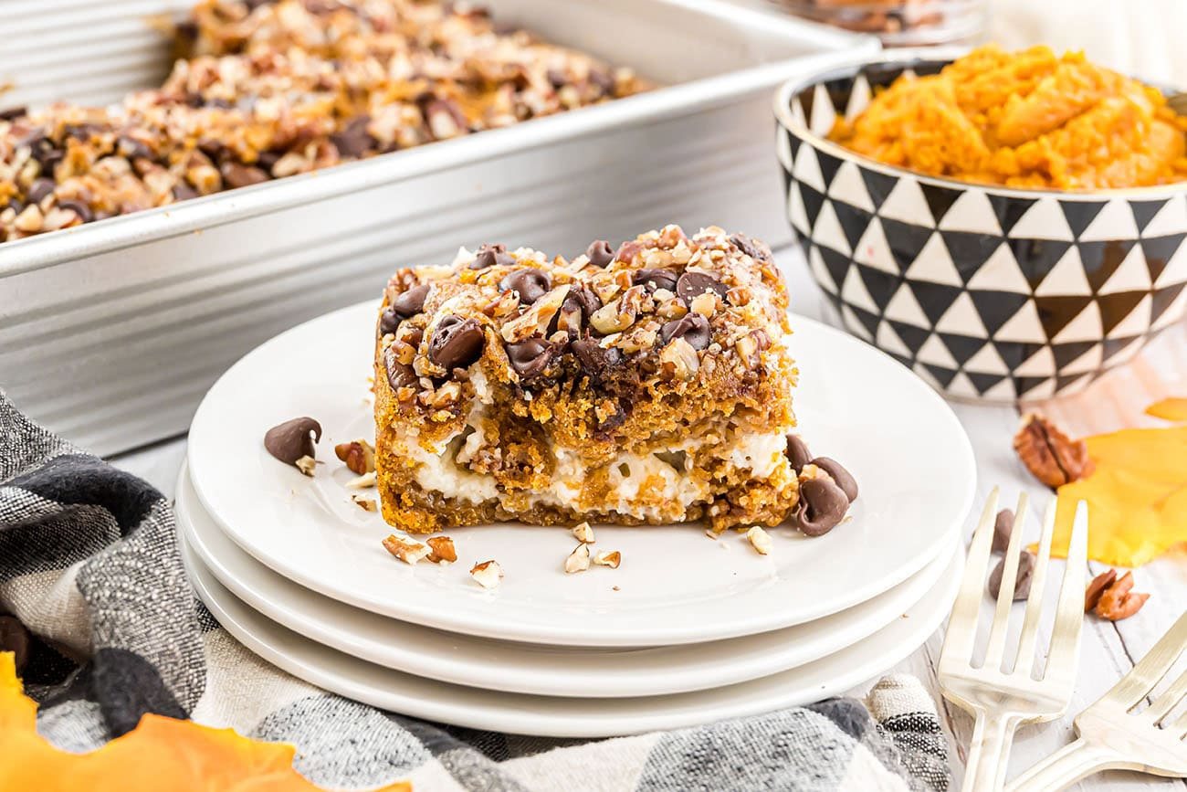 Pumpkin Earthquake Cake with pure pumpkin in a small bowl in the background and the baked dessert in a pan