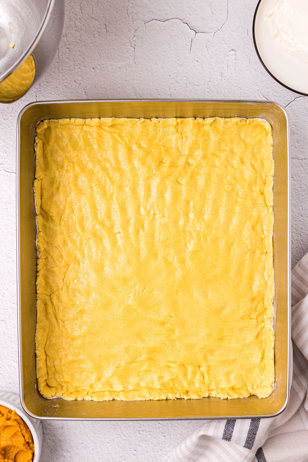 pumpkin gooey butter cake crust pressed out in a 9x13 cake pan
