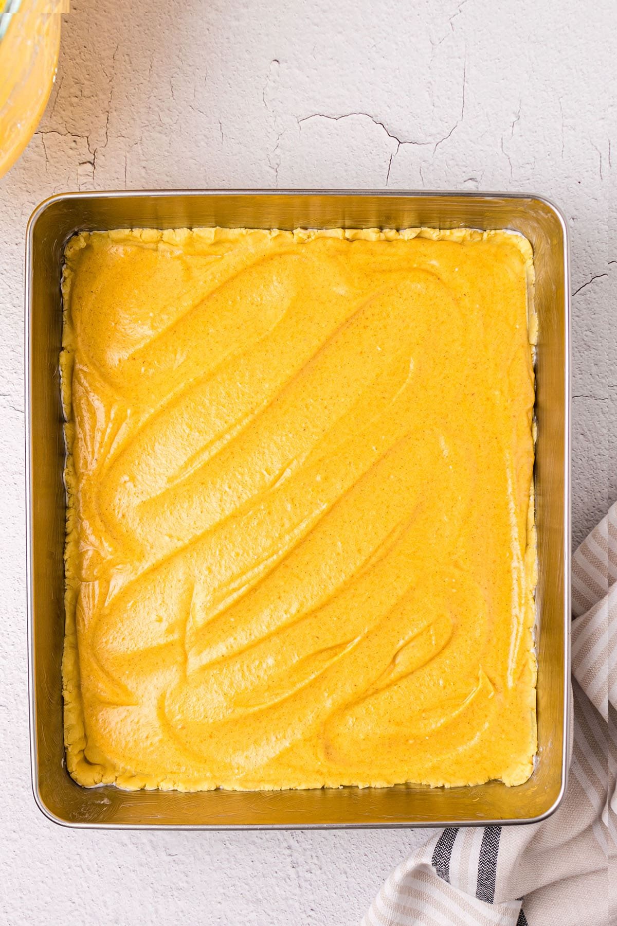 pumpkin gooey butter cake in a 9x13 pan ready for the oven