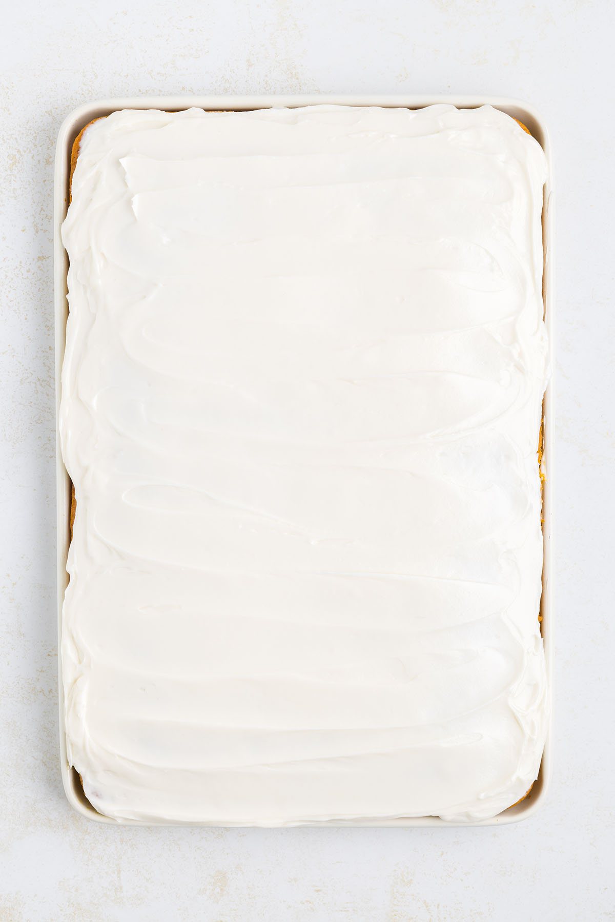 Homemade cream cheese frosting on sheet cake