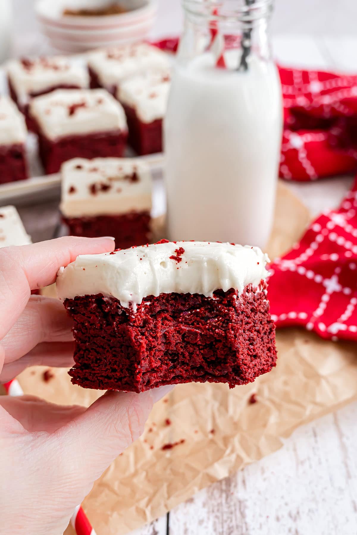 hand holding red velvet brownie with bit taken