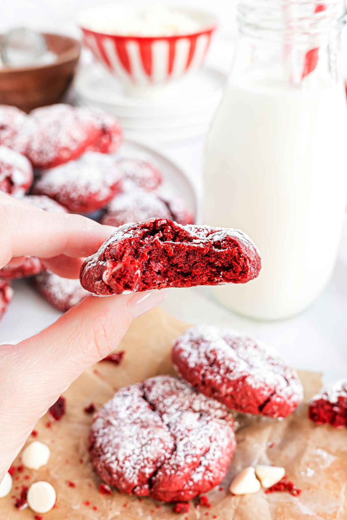 someone holding a red velvet cookie in their hand