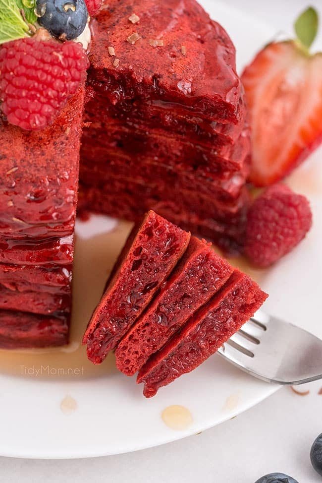red velvet pancakes with the first bite on a fork