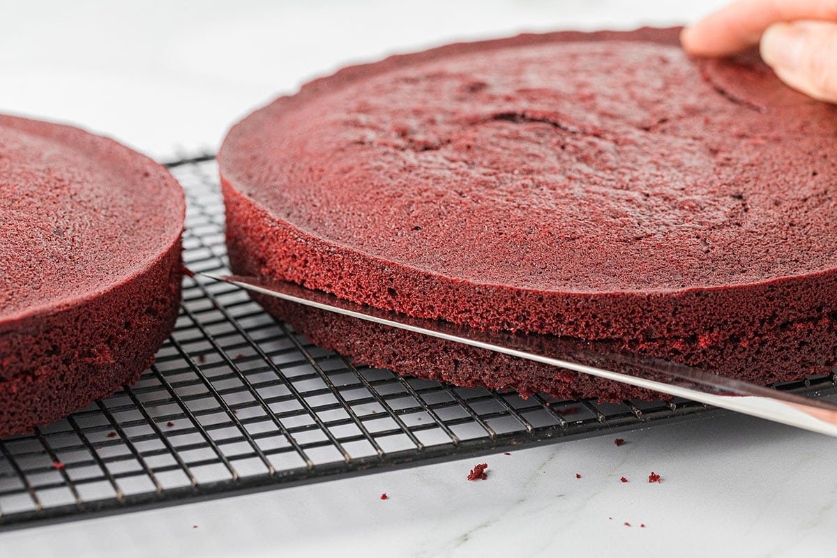 slicing red velvet cake layers in half
