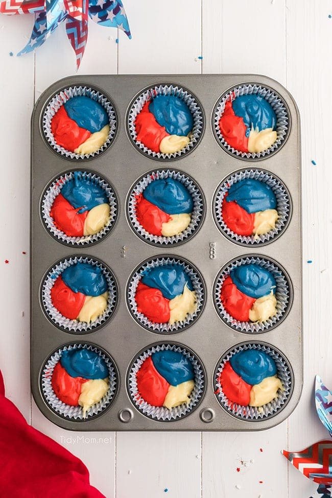 red white and blue cupcake batter in cupcake wells