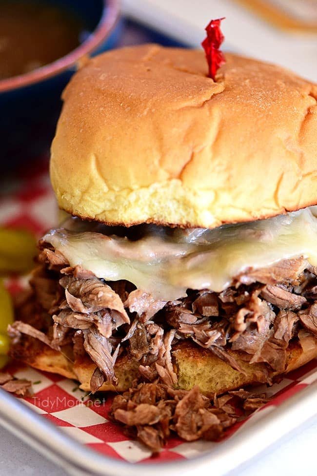 Italian beef sandwich with cheese on a red checked tray