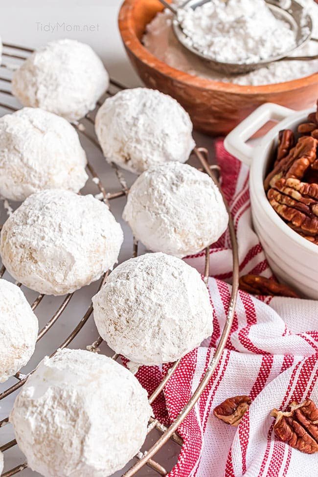 russian tea cakes on a cooling rack with a red and white towel