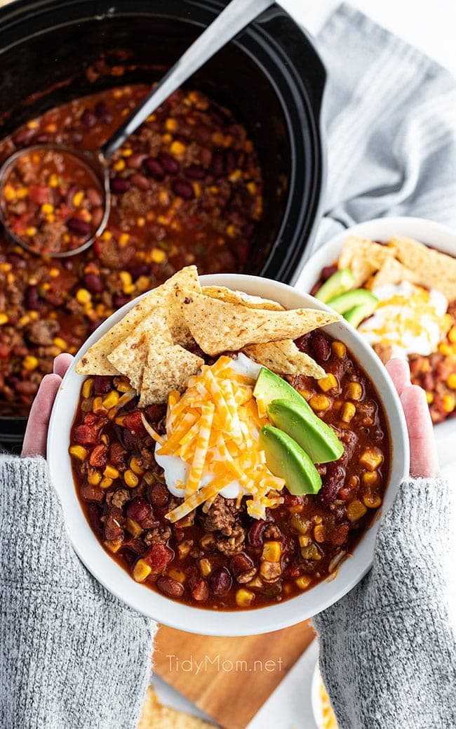 woman's hands holding a bowl of taco soup
