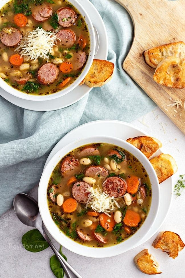 two bowls of bean soup with crusty bread on the side