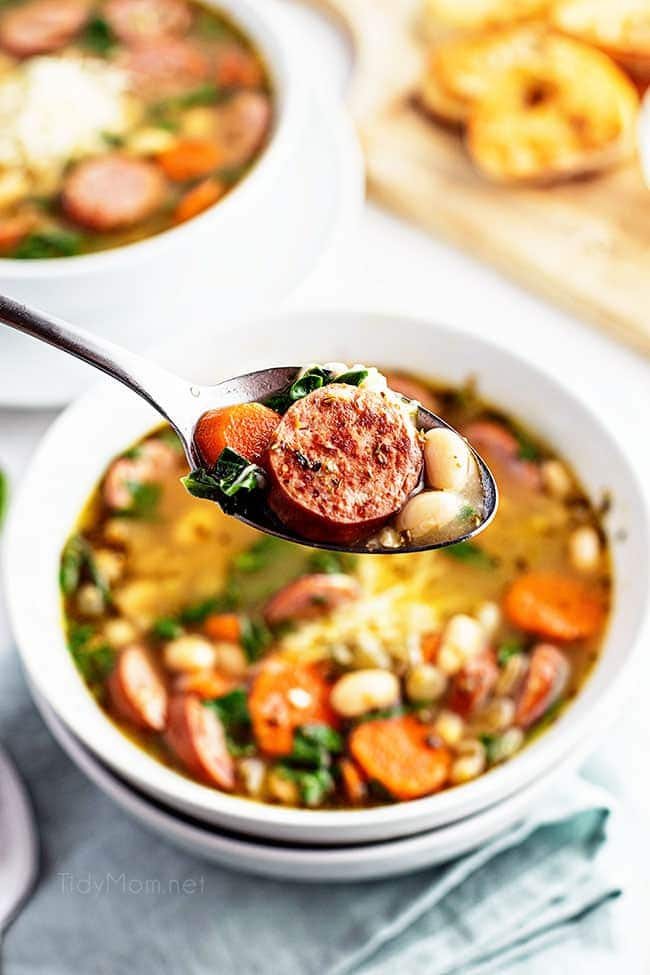 bean soup on a spoon over a bowl of soup