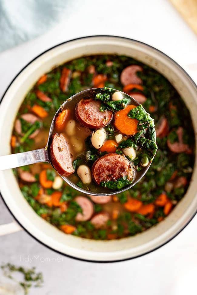 ladle full of bean soup over the pot of soup
