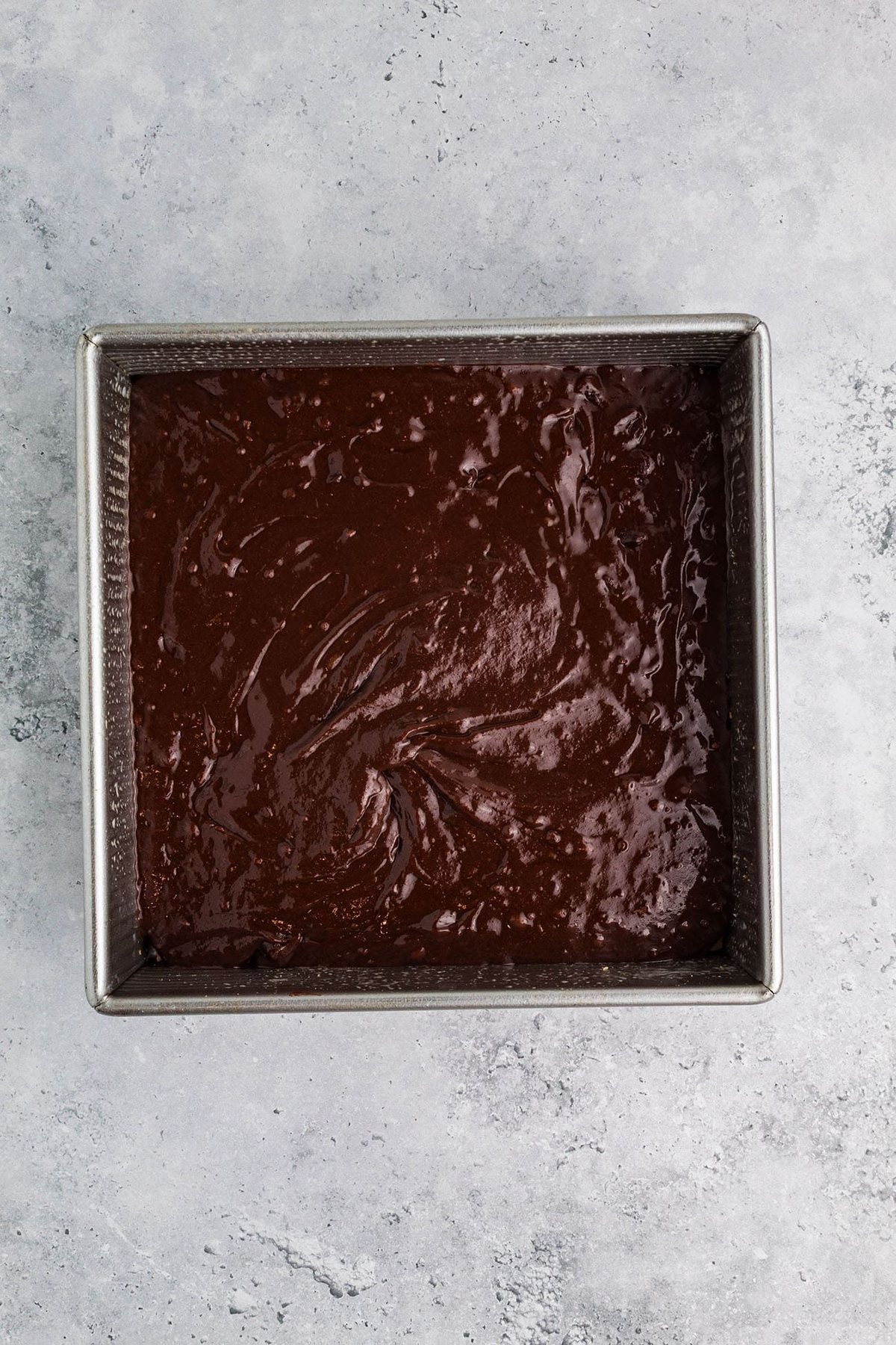 brownie batter in a square metal pan