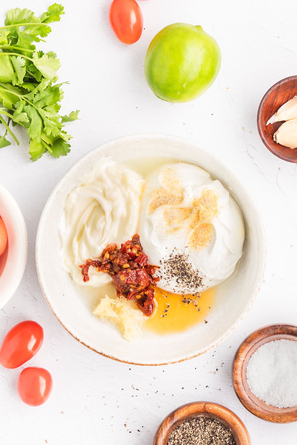 Mixing sour cream, mayonnaise, chipotle peppers, garlic, lime juice, honey, and seasonings to make creamy Southwest sauce.