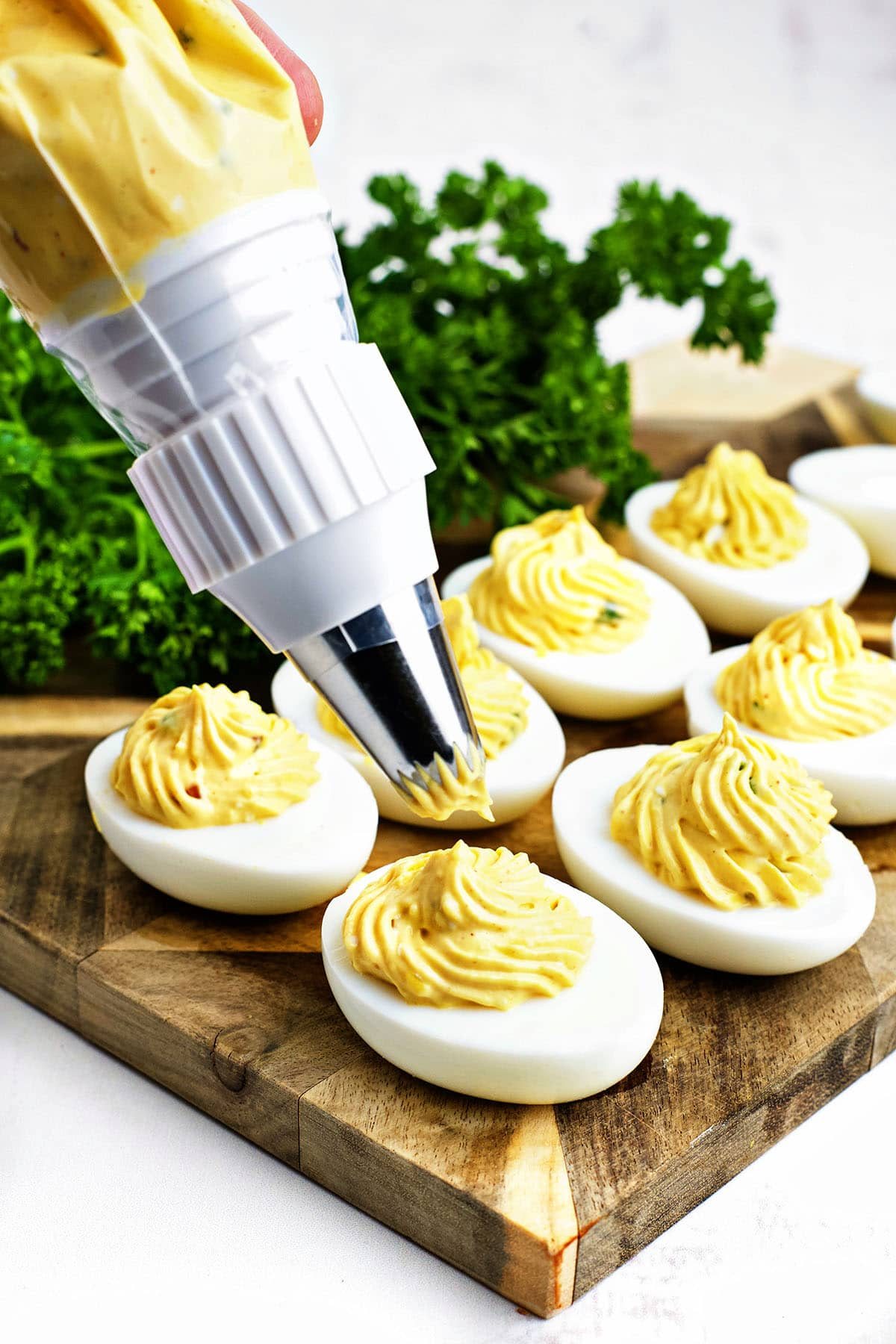 piping filling into deviled eggs