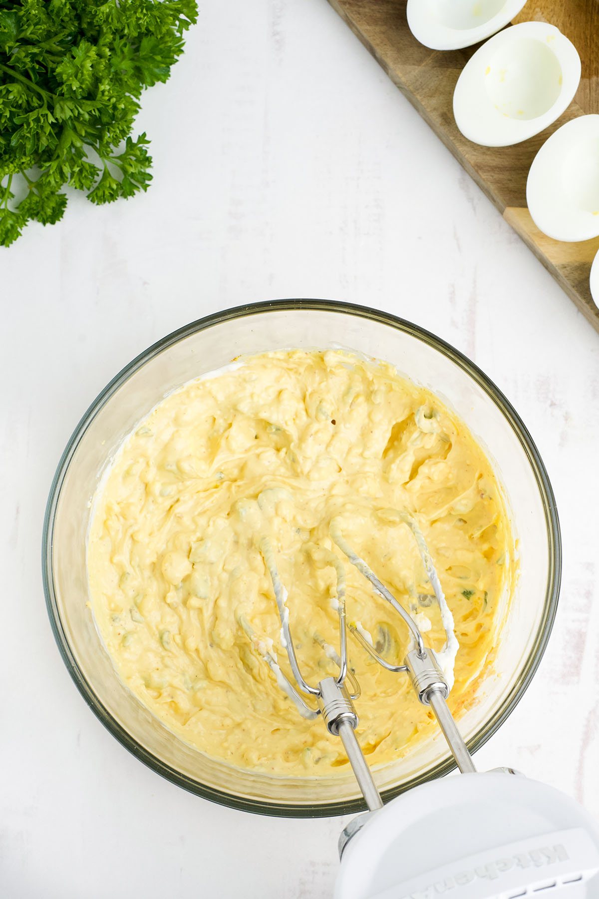 spicy deviled eggs filling mixed in a glass bowl