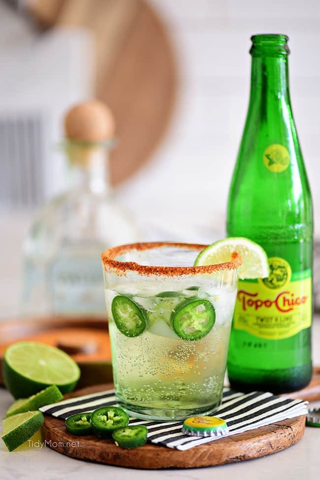 spicy ranch water in a cocktail glass next to a bottle of Topo Chico