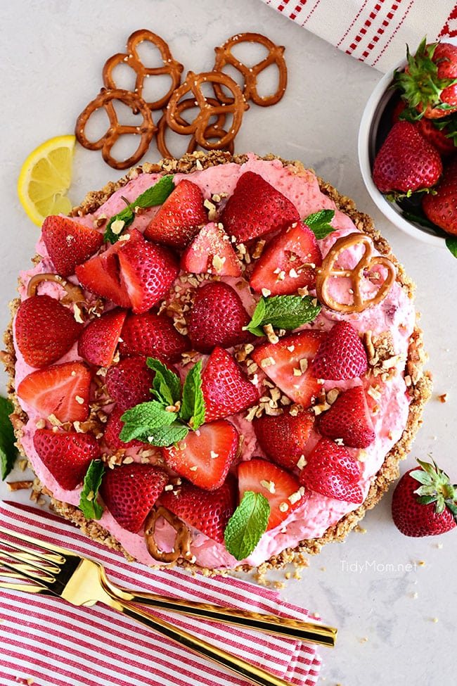 strawberry pretzel pie with 2 gold forks on a counter