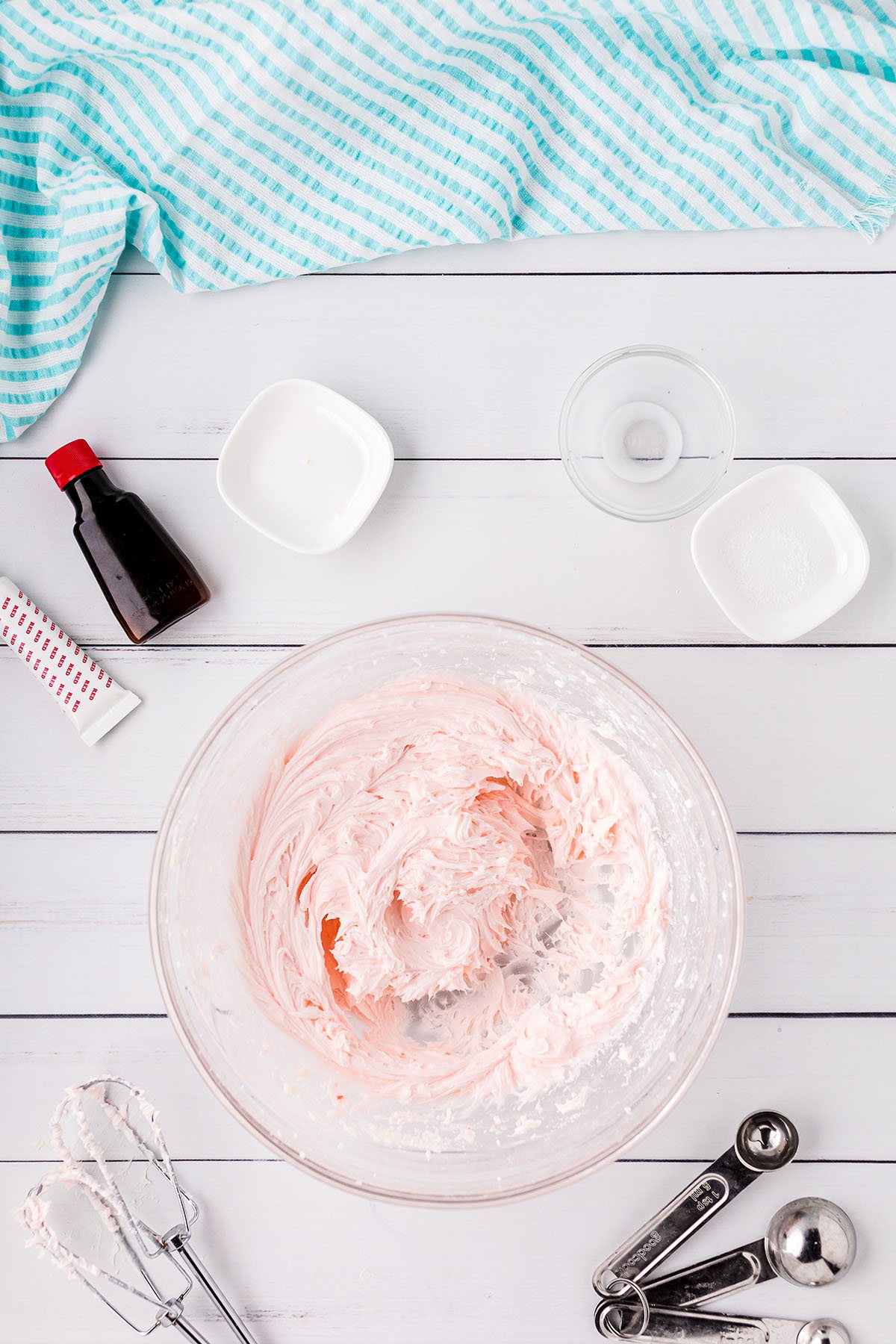 whipped pink frosting in a glass bowl