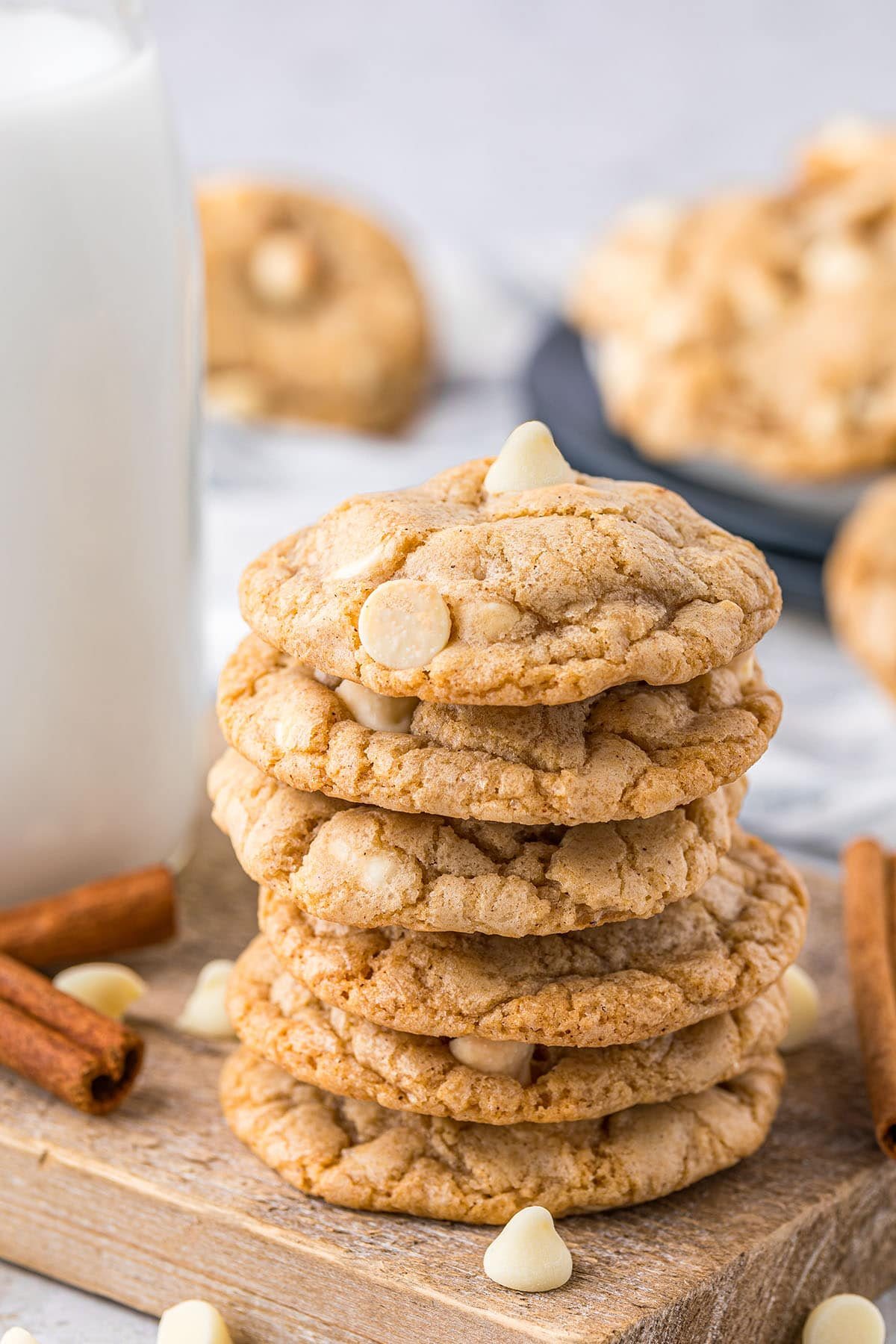 a stack of sugar doodle cookies on a wood board with a bottle of milk in the background