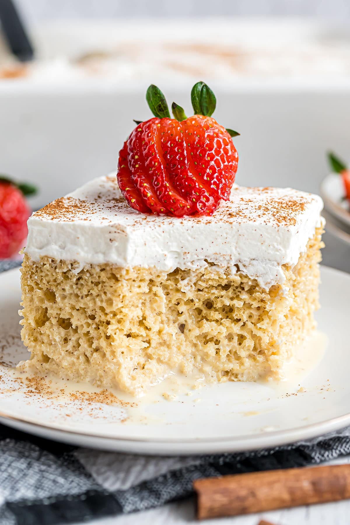 piece of tres leches cake with a bite missing on a dessert plate
