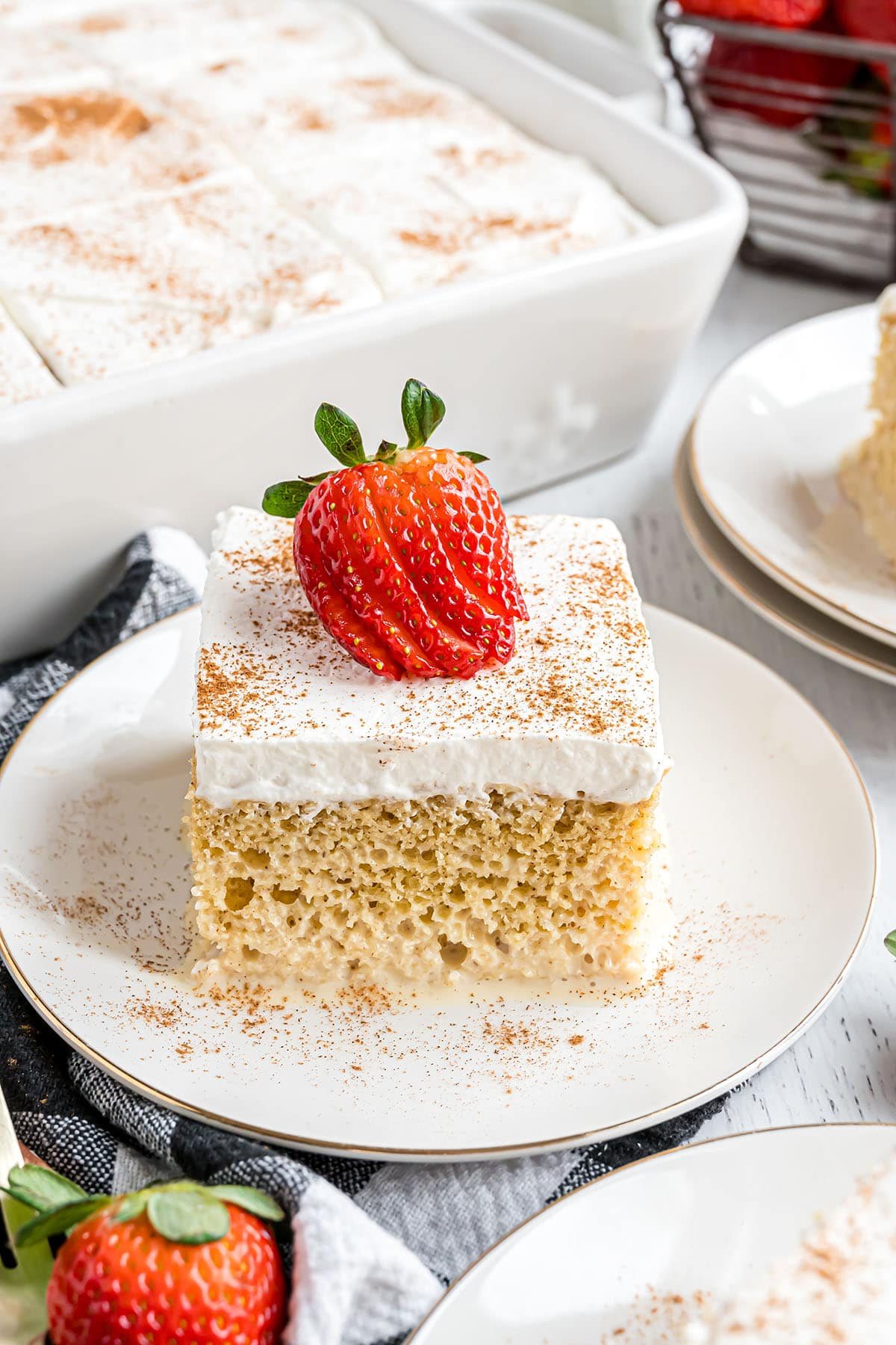 a serving of cake on a plate next to the white can pan