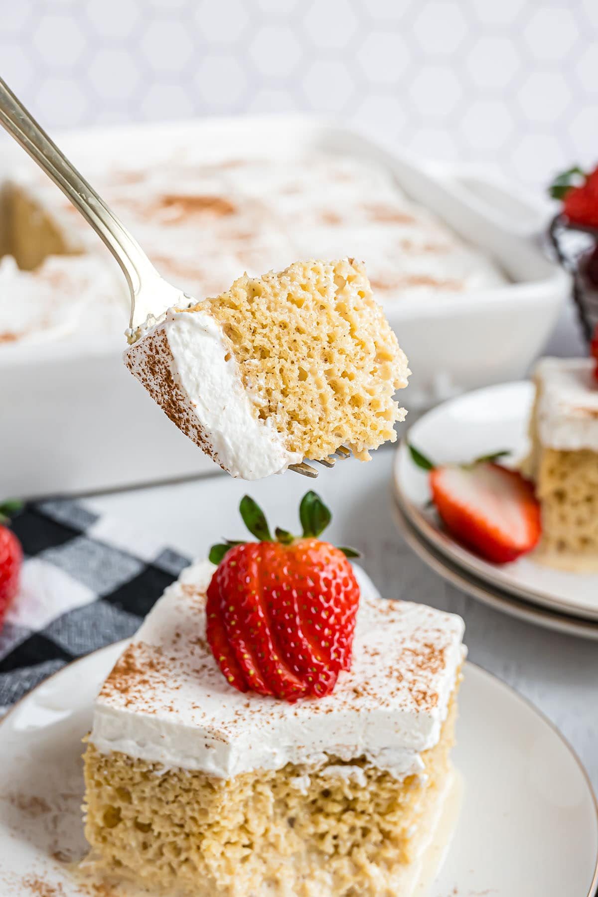 a bite of tres leches cake on a fork