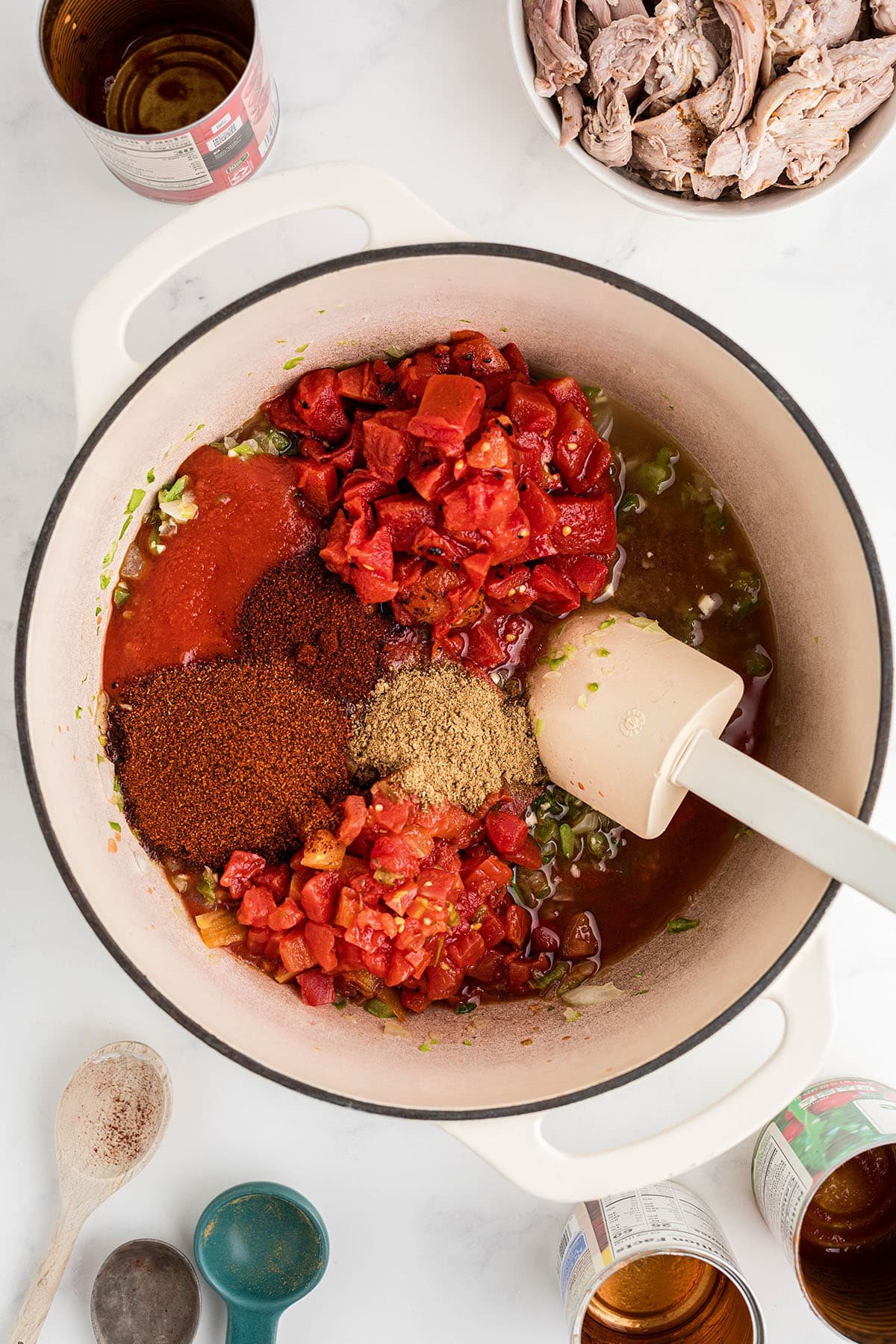 adding seasonings and tomatoes to pot of leftover turkey chili