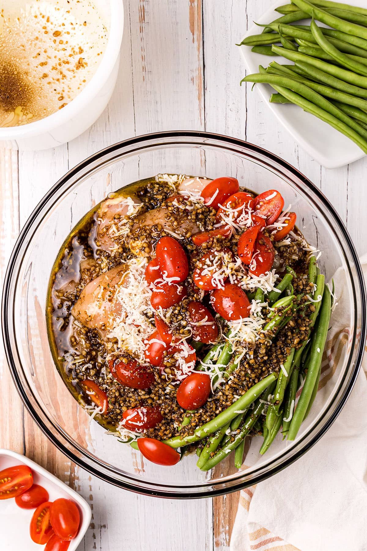 chicken tenders, green beans and tomatoes with marinade for sheet pan dinner