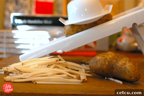 A mandoline slicer, a crucial kitchen tool for achieving uniformly cut potatoes for perfect homemade french fries