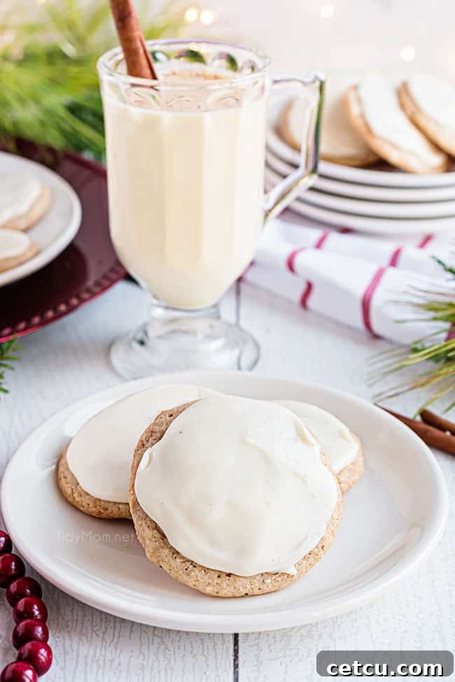A refreshing glass of eggnog stands beside a plate of delicious eggnog cookies, ready for a cozy holiday moment.