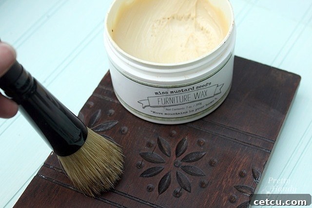 Applying furniture wax to the reclaimed wood sconce for a beautiful finish