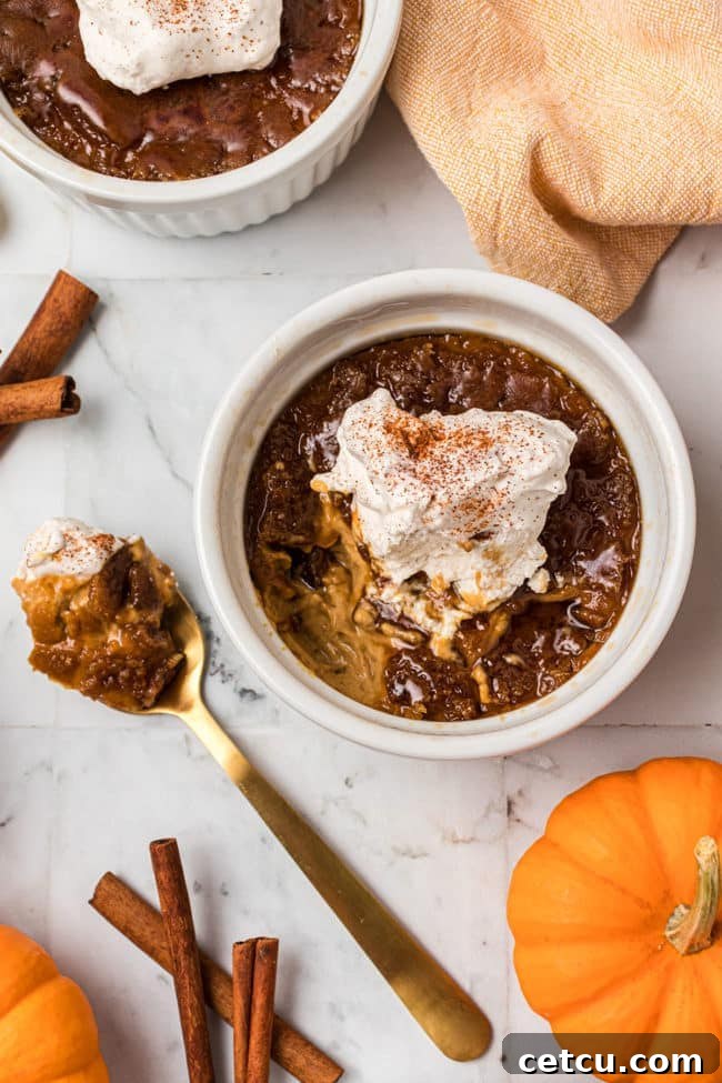 A serving of Pumpkin Crème Brûlée with a spoon breaking through its crackly caramel top, revealing the creamy custard beneath.