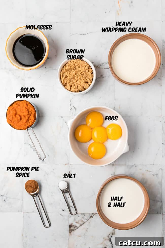 A flat lay of all the fresh ingredients for Pumpkin Crème Brûlée, including heavy cream, half and half, pumpkin puree, spices, eggs, molasses, and brown sugar, artfully arranged on a wooden background.