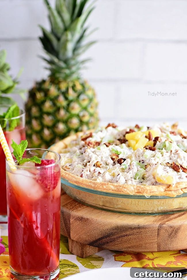 Whole Pineapple Chicken Salad Pie in a glass pie plate, showcasing its golden crust and delicious filling.