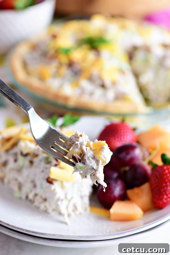 A close-up shot of a fork holding a perfect bite of Pineapple Chicken Salad Pie, highlighting the creamy filling and flaky crust.