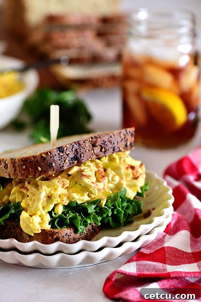 Classic egg salad sandwich on a stack of plates, ready to be enjoyed.