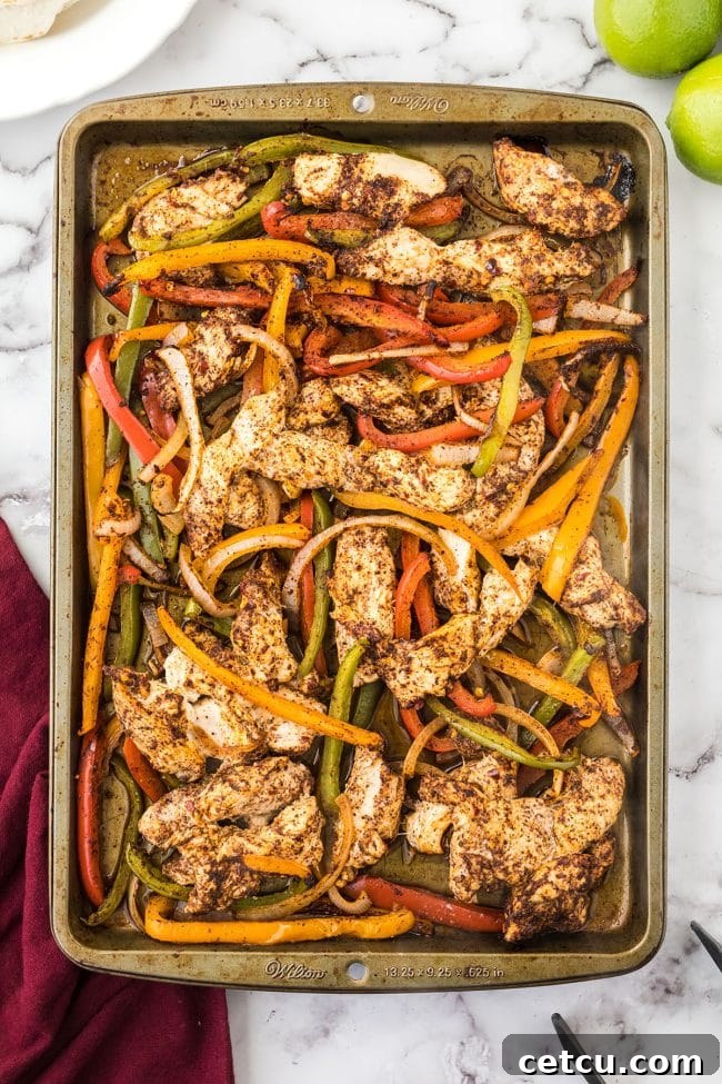 Freshly baked sheet pan chicken fajitas, hot out of the oven, with a slight char on the edges.
