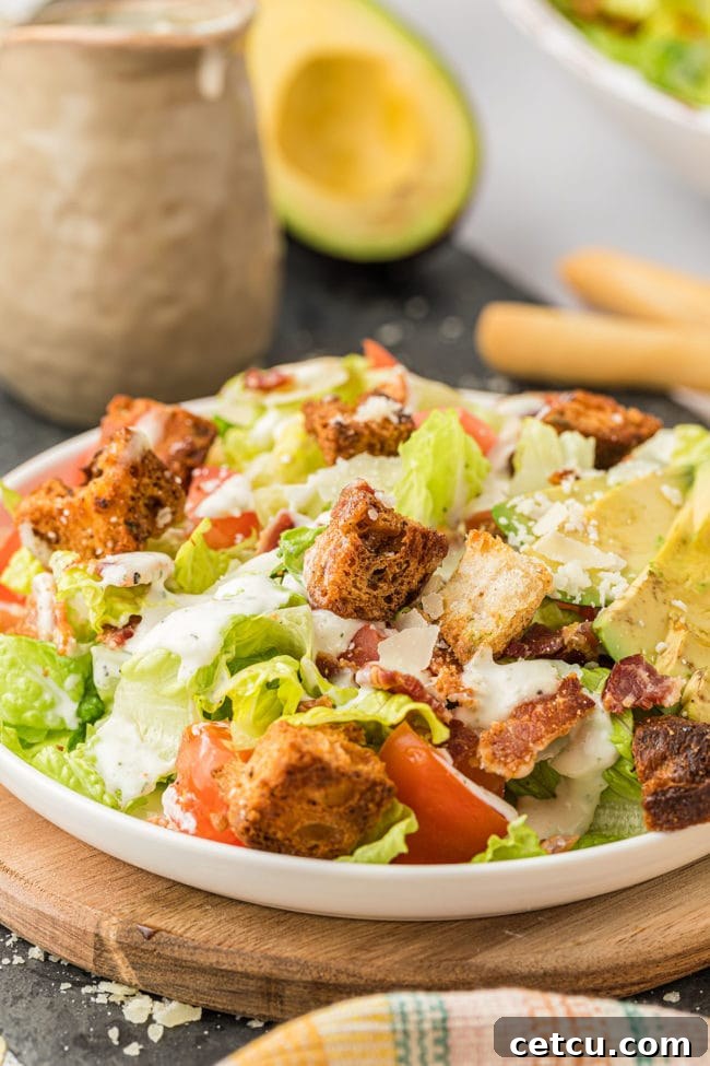 A bowl of BLT salad featuring creamy homemade dressing generously drizzled over the fresh ingredients.