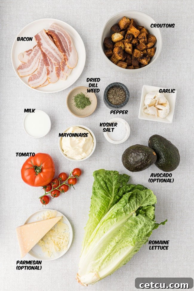 Fresh ingredients laid out for BLT salad and homemade creamy dill dressing, including bacon, lettuce, tomatoes, dill, garlic, and mayonnaise.