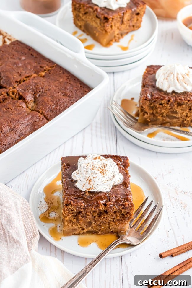 Spiced Apple Gingerbread Cake 2 A beautifully plated slice of Gingerbread Apple Cake, adorned with a swirl of fluffy whipped cream and a decadent drizzle of golden caramel syrup, ready to be enjoyed with a fork.