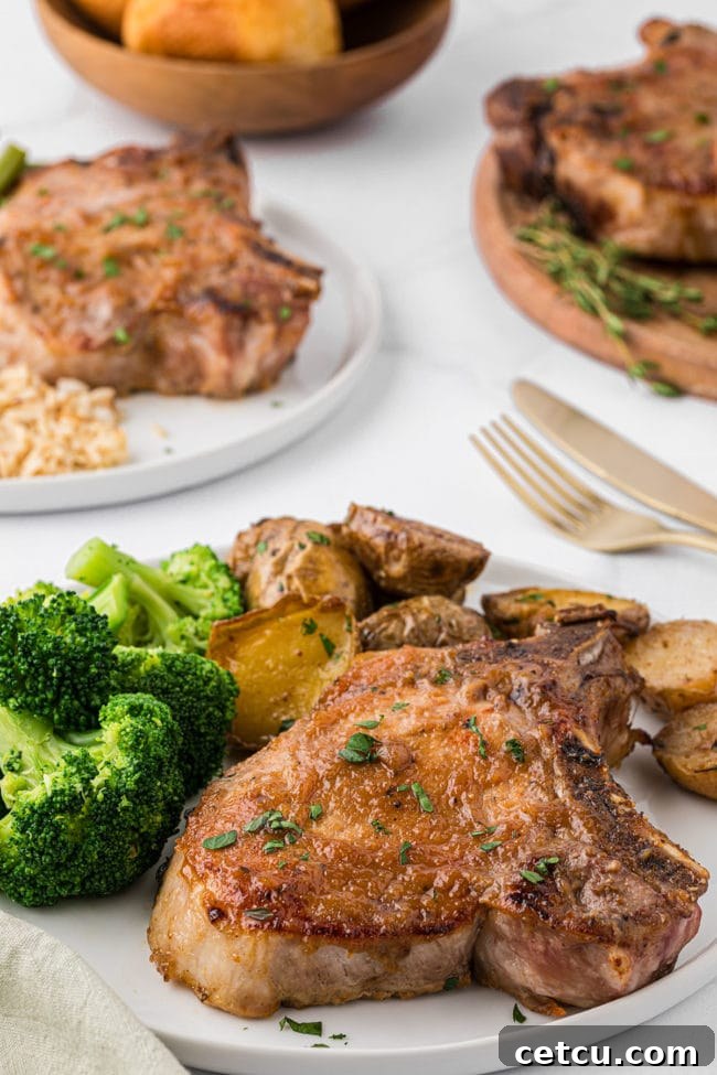 apple butter glazed pork chops on a plate with potatoes and broccoli on a dinner table