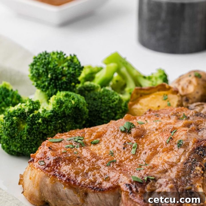 a plate with a glazed pork chop and steamed broccoli