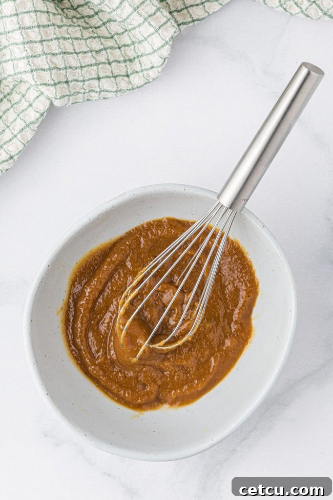 apple butter glaze for pork chops in a bowl with a whisk