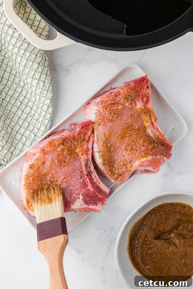 apple butter glaze being brushed on pork chops