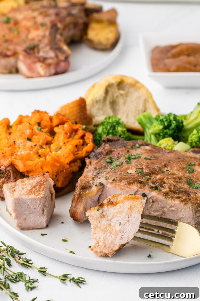 a bite of pork chop on a fork on a dinner plate