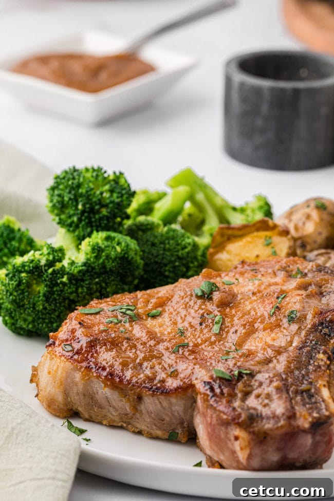 a plate with a glazed pork chop and steamed broccoli