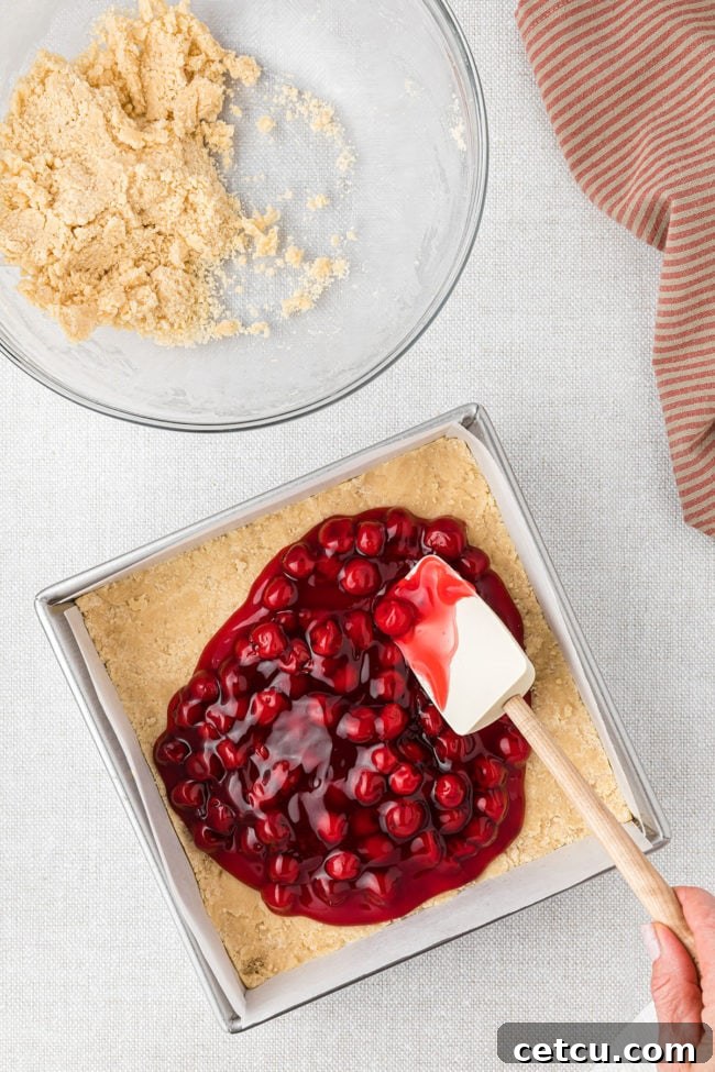 canned cherry pie filling spread over crust in square pan
