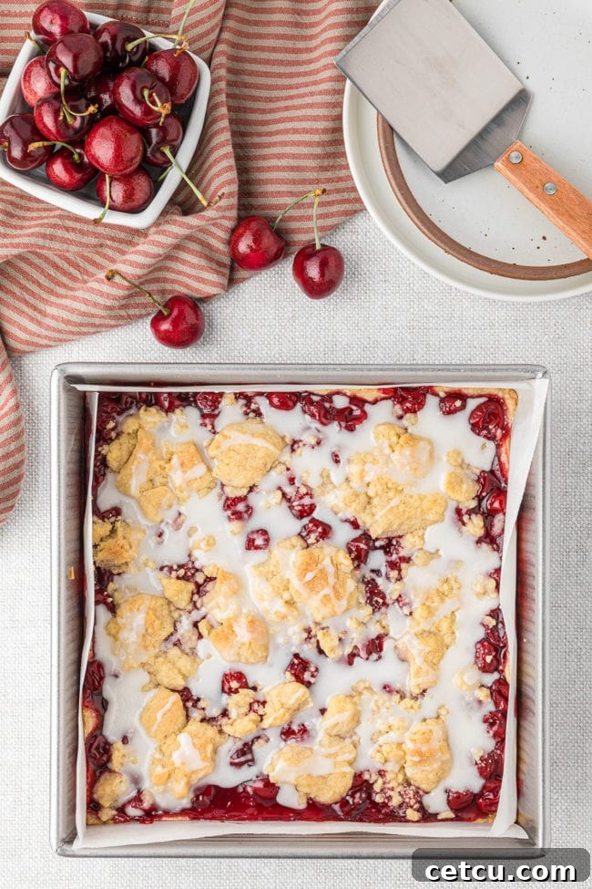 cherry pie bars with an almond glaze in a baking pan