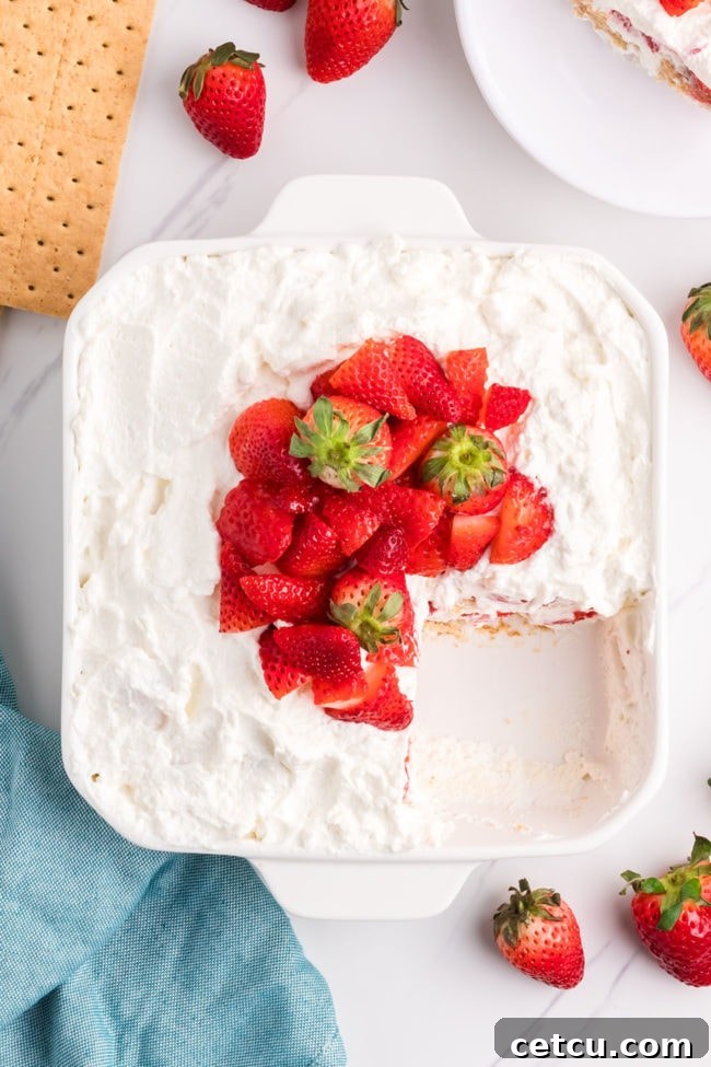 A beautifully chilled and set no-bake strawberry icebox cake, ready to be sliced and served, showcasing its vibrant layers.